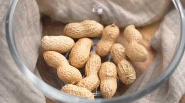 Kavrulmuş fıstıklar cam kaseye dökülüyor kırışık bez peçeteye yavaş çekimde yakın çekimde