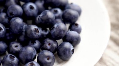 Mutfak kasesindeki meyveli yaban mersinli kumaş masa örtüsü. Olgun besleyici böğürtlen süper yiyeceği. Döndürme