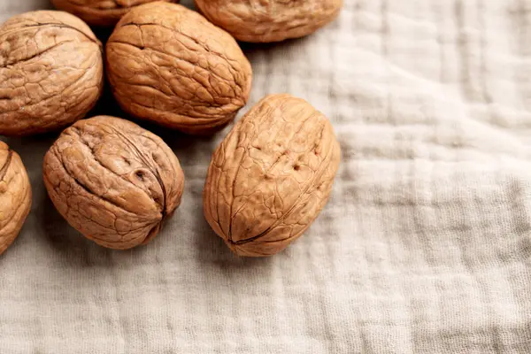 Kumaş mutfak masa örtüsünün üstündeki cevizleri kapat.