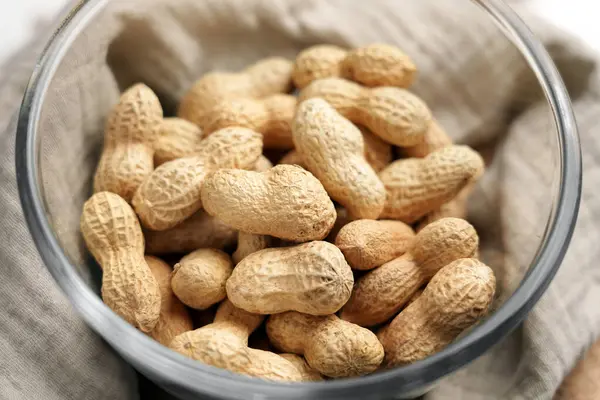 Cam kasede kabuksuz yer fıstığı ve mutfak peçetesi.