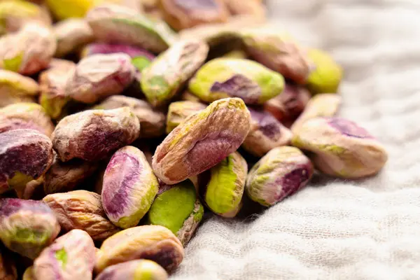 Fırınlanmış kabuklu fıstık, kumaş peçeteye serpiştirilmiş. Makro çekim