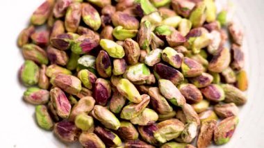 Kabuklu şam fıstığı ağır çekimde dönen tabağın üzerine düşüyor.