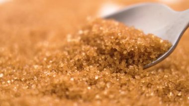 Kahverengi kamış şeker kristalleri bir çay kaşığında. Makro çekim