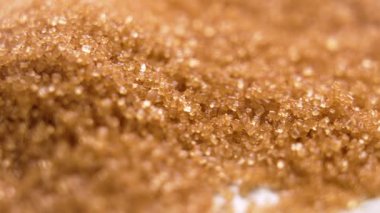 Parlak parçacıkları olan kristal kahverengi kamış şekeri. Makro atış. Döndürme
