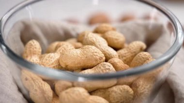 Bez peçetede cam kasede kabuksuz fıstık kızartması. Yakın plan. Döndürme