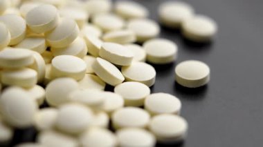 Siyah yüzeye yığınla sarı ilaç. Makro atış. Döndürme