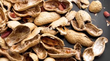 Siyah seramik tabakta fıstık kabukları. Üst Manzara. Makro atış. Döndürme