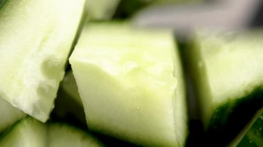 Paslanmaz çelik çatal, sebze salatasında bir parça taze salatalık topluyor. Makro çekim