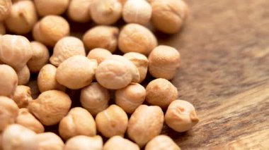 Ahşap masa yüzeyinde çiğ nohut. Makro atış. Döndürme