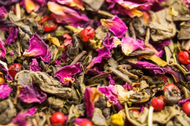 Düşen yapraklar ve yeşil bitkisel çiçek çayı, papatya çayı, amber çiçeği, kırmızı biber. Makro çekim.