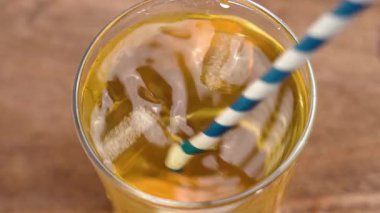 Buzlu taze çay içecekler ve ahşap masadaki bardakta kamış karıştırıcı soğuk sıvı içecekler.