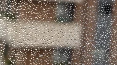 Yağmurla kaplı ıslak bir pencereyi açıyorum.