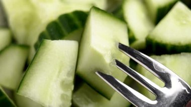 Bir kase yeşil sebze salatası üzerine taze organik salatalık dilimi. Üst Manzara. Makro çekim