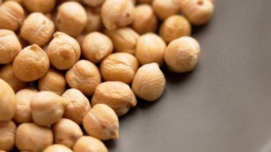 Mutfak seramik kasesinde nohut ya da kuru fasulye. Pişmemiş baklagil tohumları. Makro atış. Döndürme