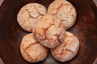 Taze pişmiş zencefilli kurabiyeler ve ahşap kasede çatlak dokular. Üst görünüm. 