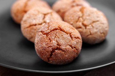 Taze pişmiş zencefilli kurabiyeler ve siyah seramik tabakta parçalanmış dokular. Makro çekim. 