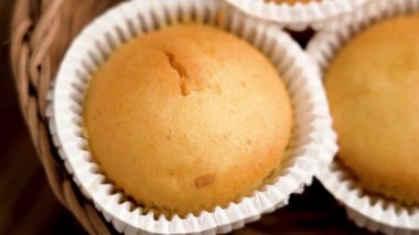 Kekler ya da beyaz kağıt bardaklı muffinler. Çevre dostu hasır rattan kâse. Üst Manzara. Döndürme
