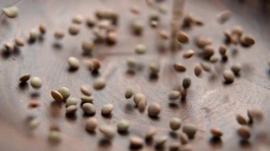 Kuru mercimekleri yavaş çekimde ahşap bir kaseye düşürmek. Besleyici bileşen. Beslenme lifleri. Döndürme