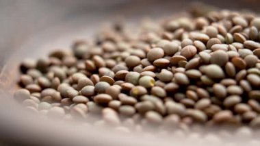 Ahşap kase pişmemiş mercimek malzemesi. Çiğ baklagiller. Makro atış. Döndürme