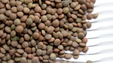 Karton karton kağıt üzerinde kuru mercimek. Yakın plan. Pişmemiş besin maddesi. Beslenme lifleri. Döndürme