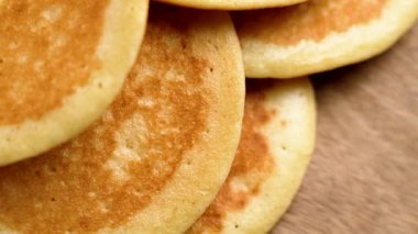 Ahşap yüzeyde ev yapımı altın krep yığını. Makro atış. Üst Manzara. Döndürme