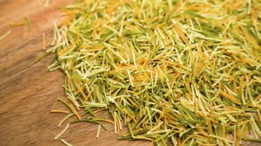 Ahşap masada çok renkli, ince İtalyan vermicelli. Pişmemiş organik geleneksel makarna. Döndürme