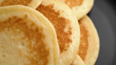 Siyah seramik tabakta yumuşak ev yapımı buğday krepleri. Üst Manzara. Döndürme