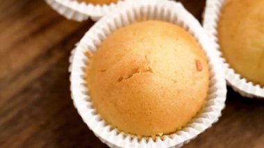 Tahta masanın üzerinde beyaz kağıt kaplamalı çörekler. Makro. Üst görünüm