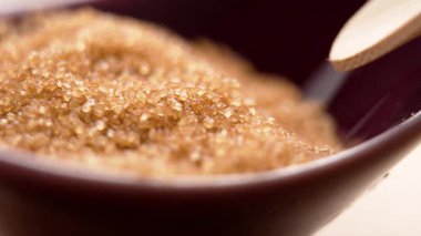 Kahverengi organik şeker. Bambu kaşığı tatlı malzemelerden kristaller topluyor.