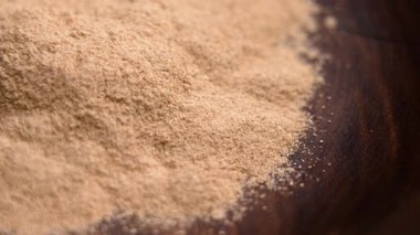 Ahşap kasede Ayurvedic Ashwagandha kökü tozu. Sakinleştirici anti-stres takviyesi. Döndürme