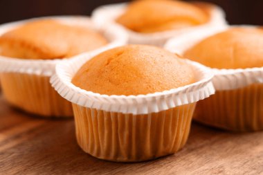 Tahta masadaki kağıt bardaklarda taze pişmiş vanilyalı kekler.. 