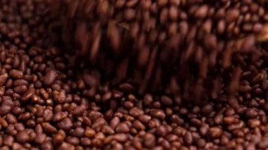 Çikolatalı kahve, baharatlı granüller yavaş çekimde tahta kaşıktan dökülüyor.