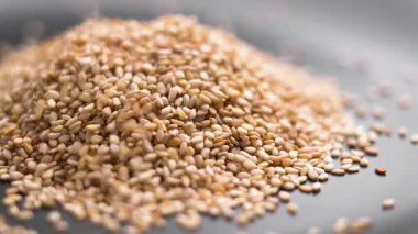 Kurumuş sağlıklı susam tohumları yığının üzerine düşüyor ve yavaş çekimde dağılıyor. Döndürme