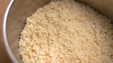 Metalik bir kap çiğ bademli tatlı unu. Organik pişirme malzemesi. Makro. Döndürme