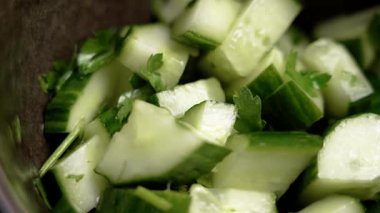 Kahverengi mutfak kasesinde maydanozlu taze yeşil sebze salatası. Makro atış. Döndürme