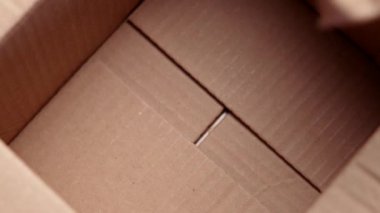 Buruşmuş kağıt doldurucuyu boş karton bir kutuya koymak. Paketleme işlemi