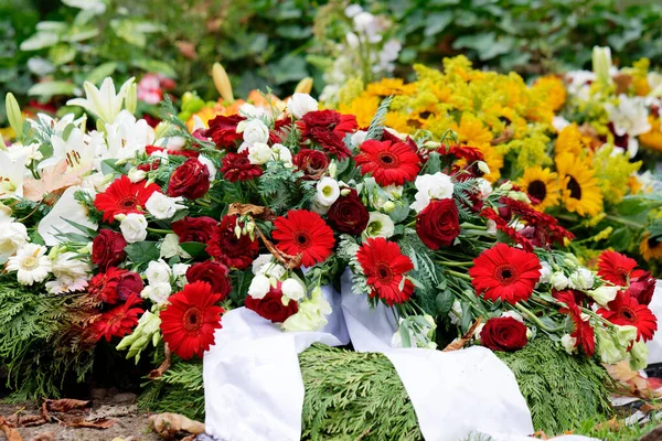 Güller, gerbera, zambaklar ve ayçiçekleri bir cenazeden sonra bir mezarda