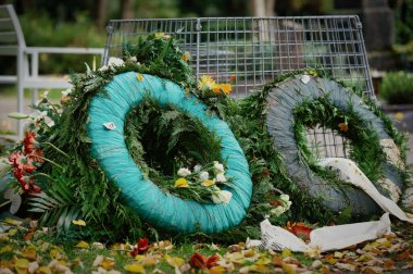 Mezarlıktaki çöp sepetinin yanındaki eski cenaze çelenkleri.