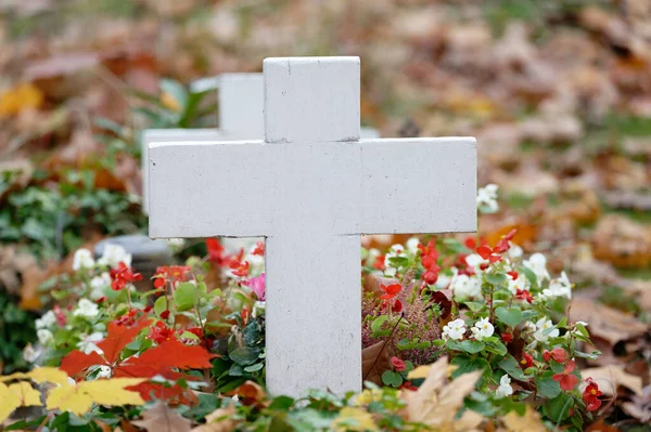 儿童坟墓的白色十字架 开满鲜花 长满秋天的叶子 — 图库照片