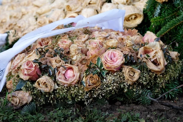 pastel withered flower decoration with roses on a grave