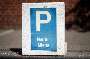 Sadece kiracılar için park yeri yazan beyaz-mavi bir tabela.-.