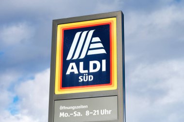 Köln, Almanya 24 Şubat 2024: Köln ehrenfeld 'de karanlık bulutlu bir gökyüzünün önünde bir Aldi mağazasının reklam tabelası