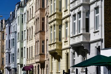 Köln 'deki Agnesviertel' in kurucu döneminden kalma koyu camlı, pastel renkli eski binalar.