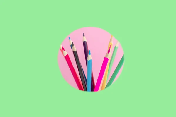 Conjunto Lápis Coloridos Espreitar Círculo Rosa Fundo Verde — Fotografia de Stock
