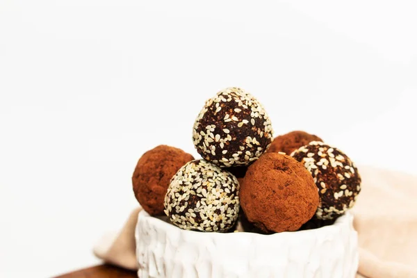 stock image Energy balls in white bowl. Healthy raw dessert, vegetarian truffles, sugar free candies made of dates, hazelnuts, cocoa powder.