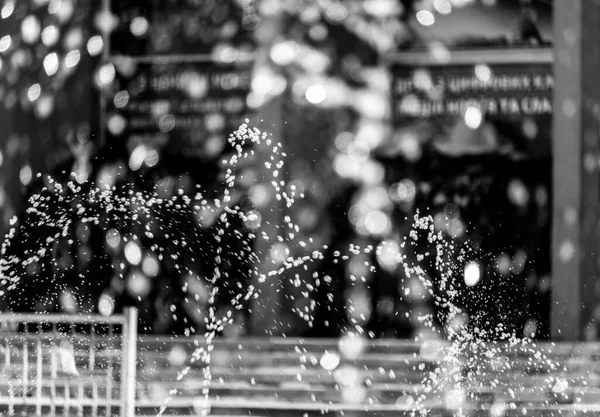 stock image Bokeh lights on black background, shot of flying drops of water in the air, defocused water drops levitation on dark, blurred