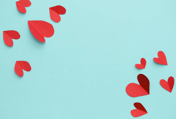 Red paper hearts isolated on blue background