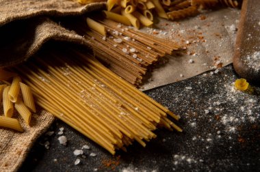 Farklı türde makarna. Makarna masanın üstünde. Çiğ makarna. Doku.