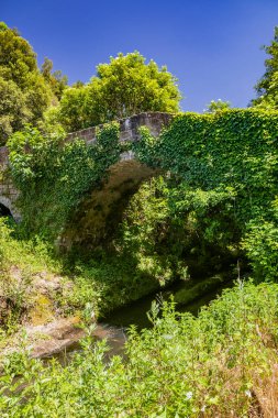 Lazio 'nun Viterbo ilindeki Corchiano adlı küçük bir ortaçağ köyü. Rio Fratta üzerindeki antik Roma köprüsü, vadi parkında, kısmen bitki örtüsüyle kaplı..