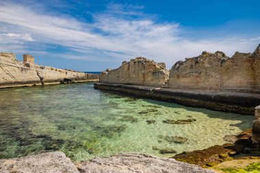 Marina Serra 'nın inanılmaz doğal havuzları, Puglia, Salento, Tricase' de. Kayalık uçurumun arasındaki berrak ve kristal turkuaz deniz. Yazın mavi gökyüzü. Eski gözetleme kulesi..